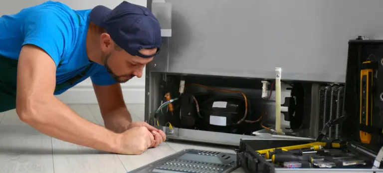 a appliance repair technician diagnosing the source of refrigerator noises