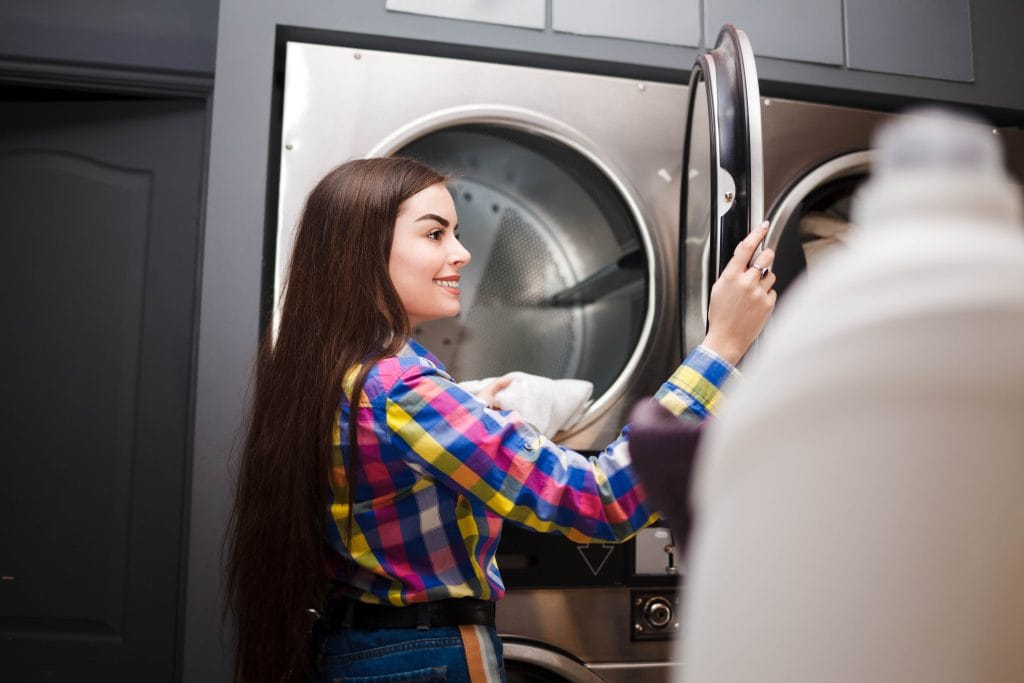 self serviece laundrette client takes things out of the dryer