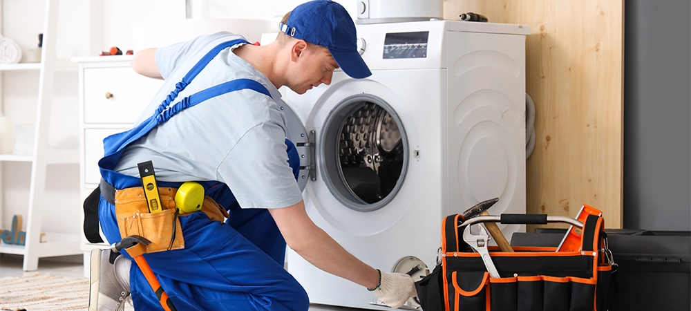 professional technician repairing washing maching Male technician repairing washing machine in bathroom