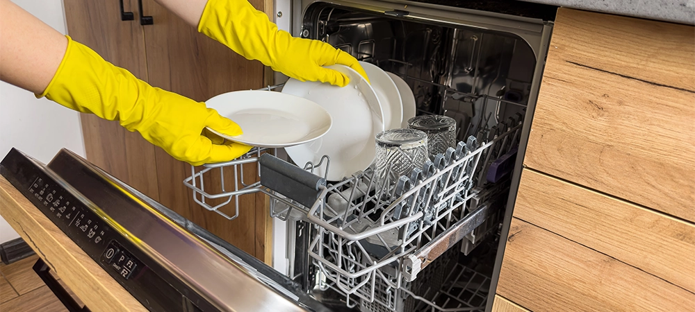 a woman loads dirty dishes into the dishwasher. The concept of routine homework
