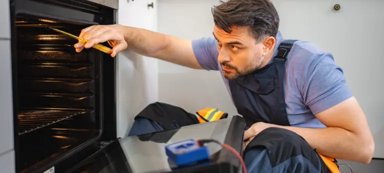 Mid Adult Technician Repairing Kitchen Oven