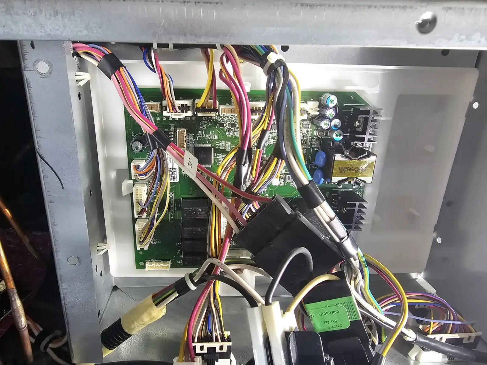 appliance repair close up electronic circuit board inside metal enclosure colore
