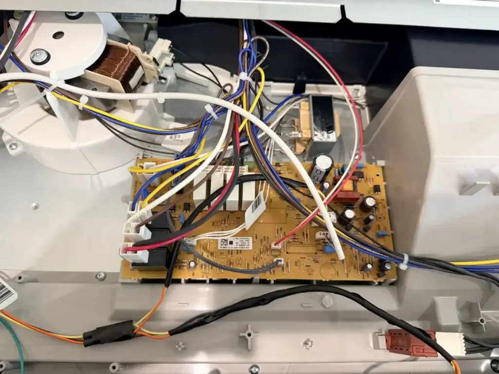 appliance repair close up open electronic device reveals yellow circuit board in