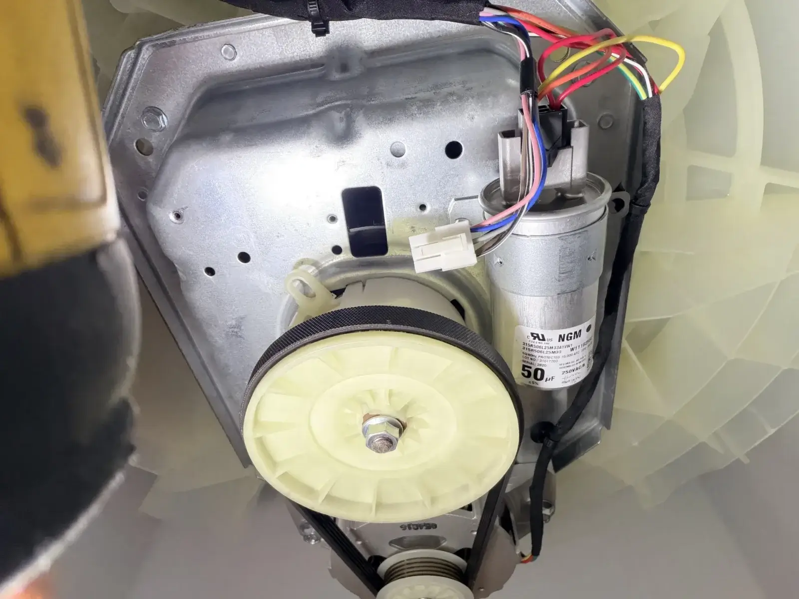 appliance repair close up view appliance motor assembly pulleys belt wires mount