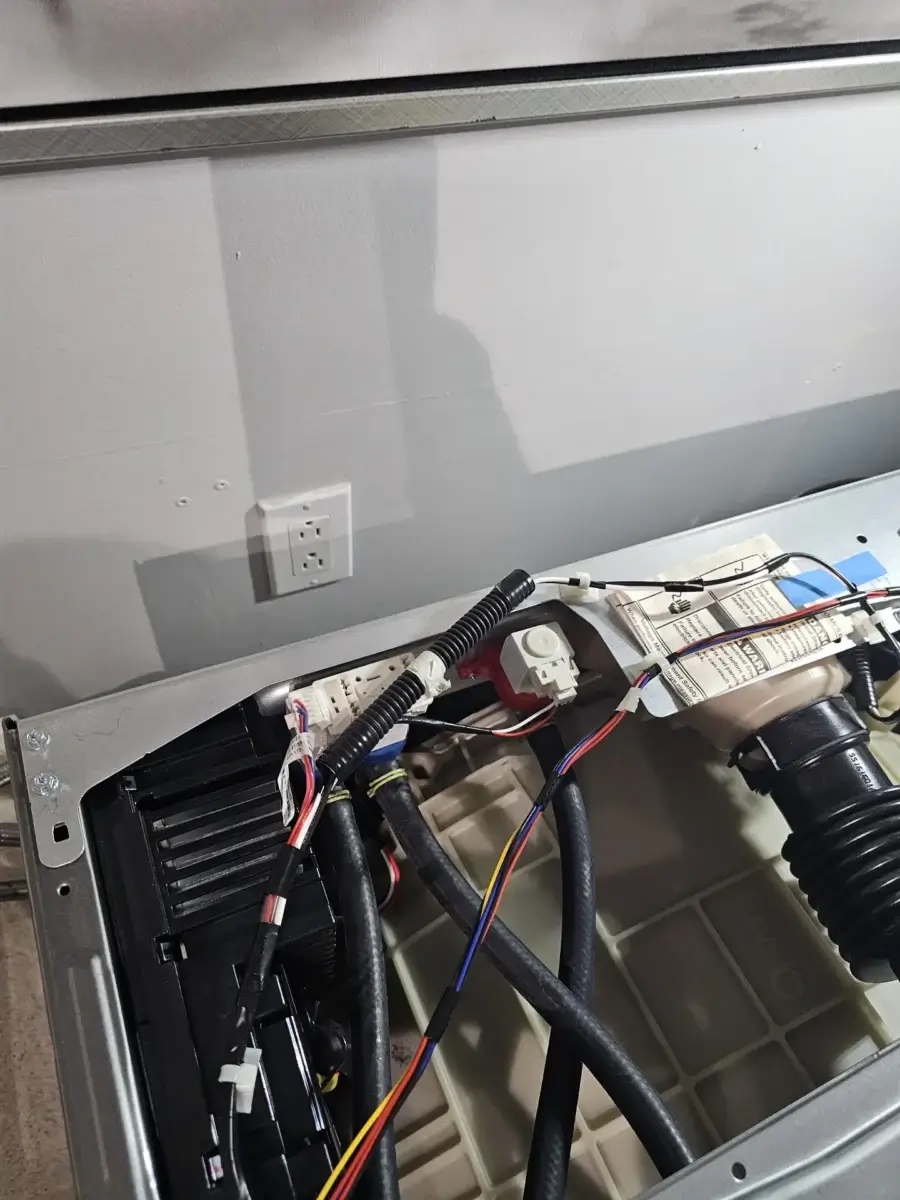 appliance repair partially disassembled appliance showing electrical wiring hose