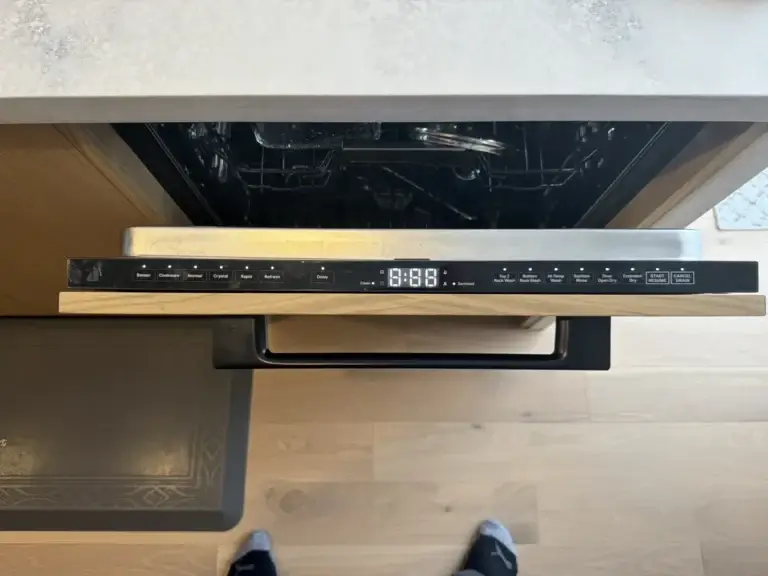 Open dishwasher door with the control strip lit during a service visit