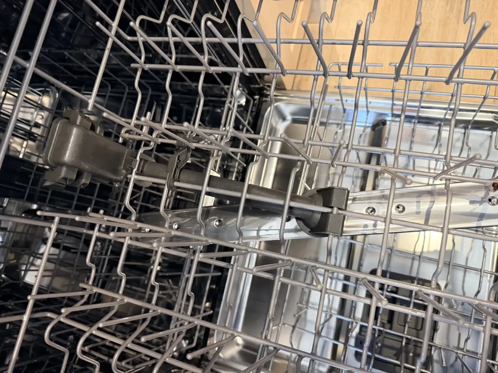 Spray arms running inside a stainless-steel dishwasher mid-cycle