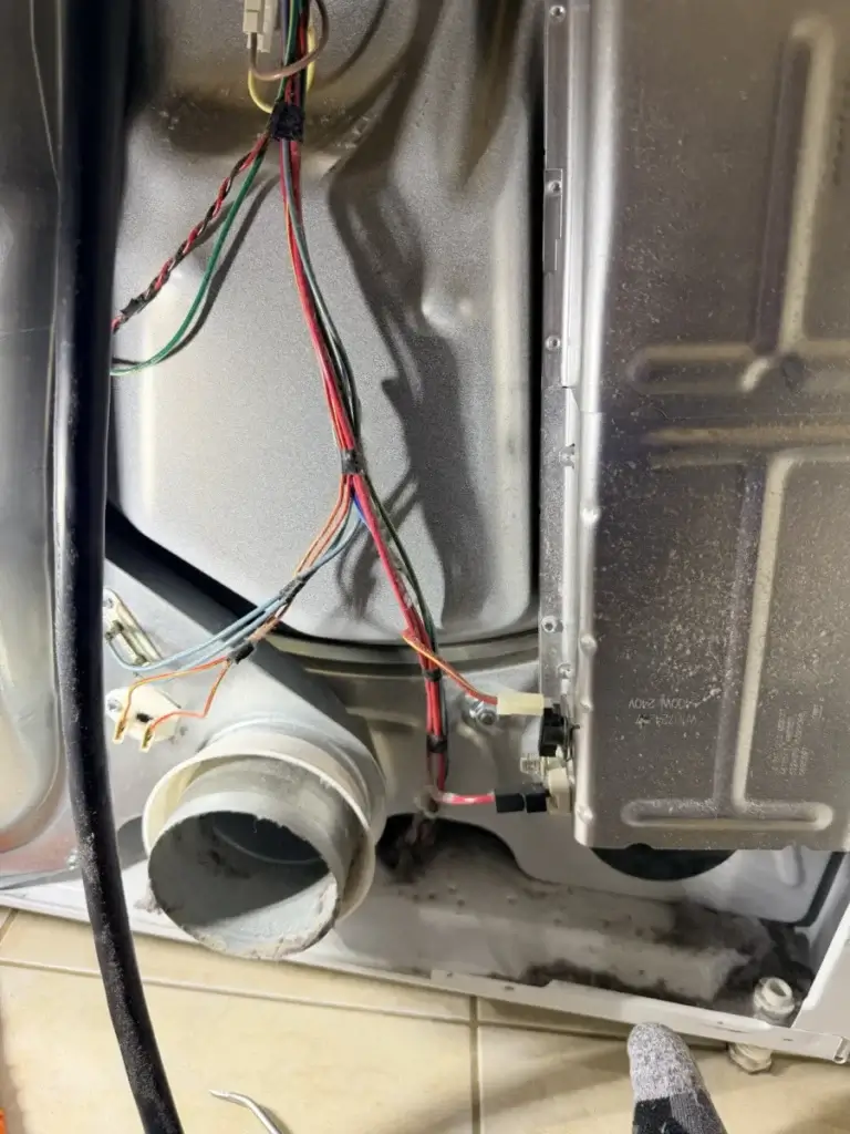 Close-up inside a dryer cabinet during a strange-noise diagnosis