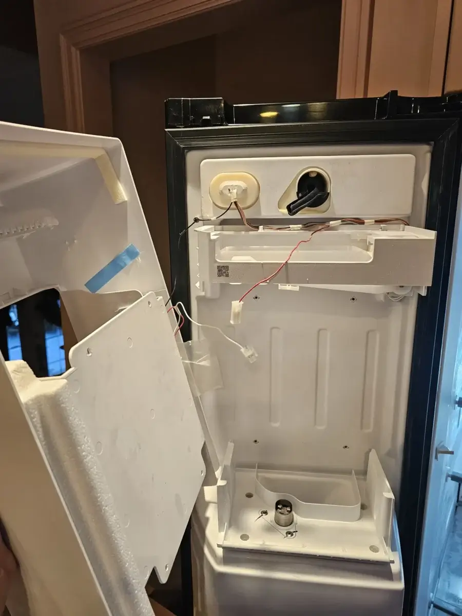 Open refrigerator door in Bradford, Ontario with the ice maker panel removed for service