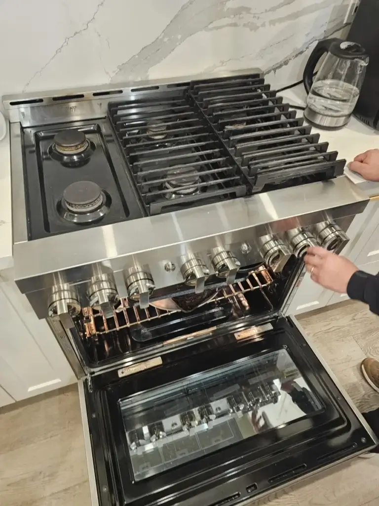 oven repair person adjusts knob stainless steel gas stove oven door open bradfor