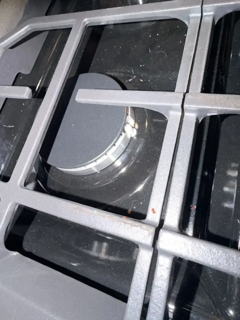 Close-up of a gas burner beneath the cast-iron grates
