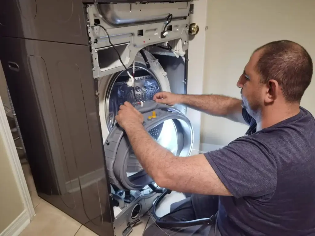 washer repair man performs appliance repair washing machine front panel removed