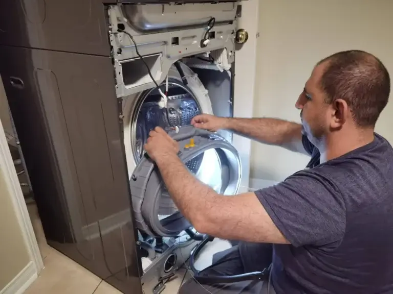washer repair man performs appliance repair washing machine front panel removed