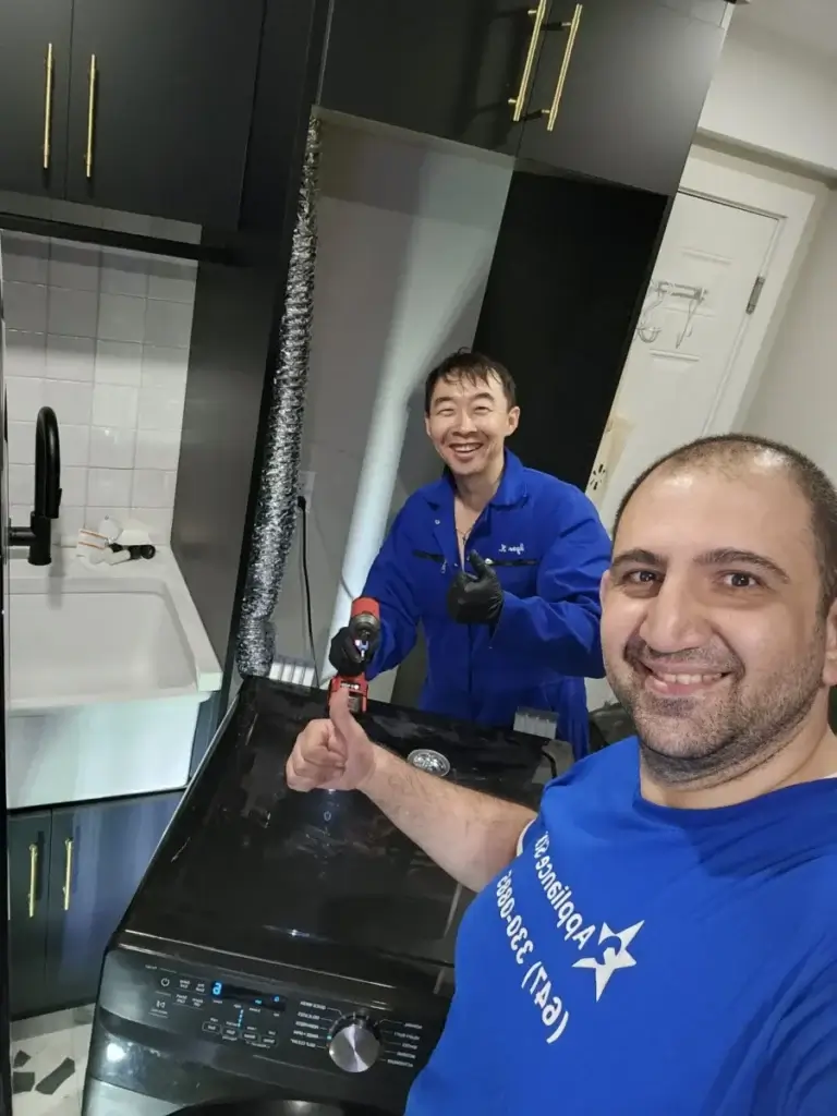Two Appliance Forever technicians giving a thumbs-up after finishing a washer repair