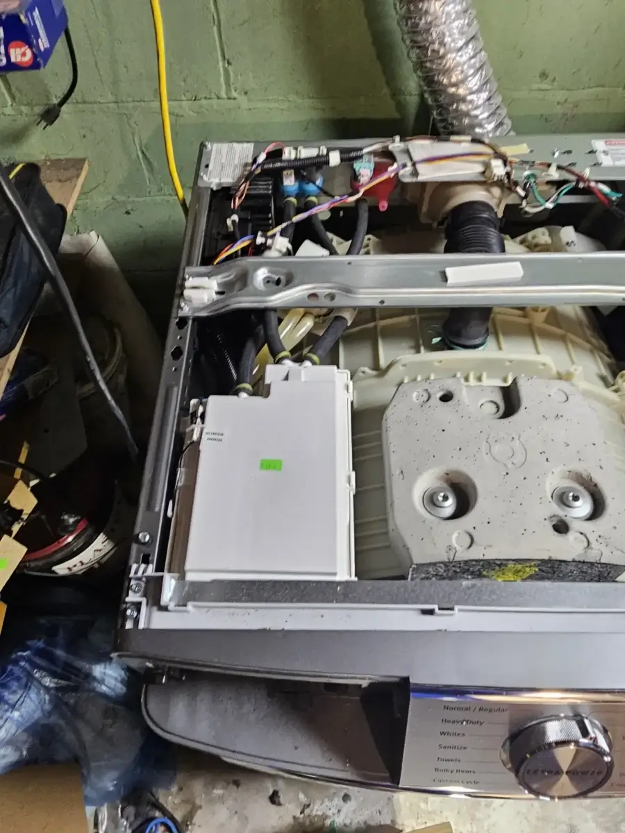 Internal components of a washing machine including the drain pump area inspected during an LG OE repair