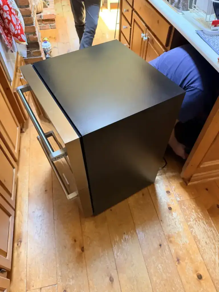 Technician pulling a built-in appliance out of the cabinetry during an in-home service call