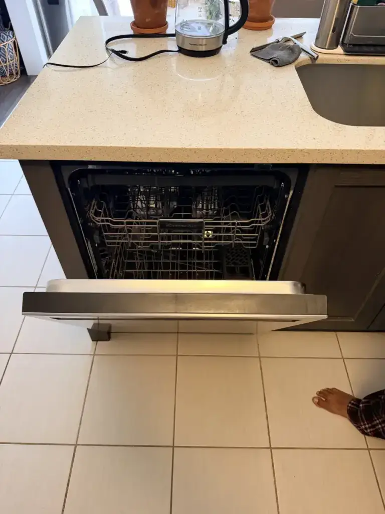 Open KitchenAid built-in dishwasher in a kitchen island - weighing repair against replacement
