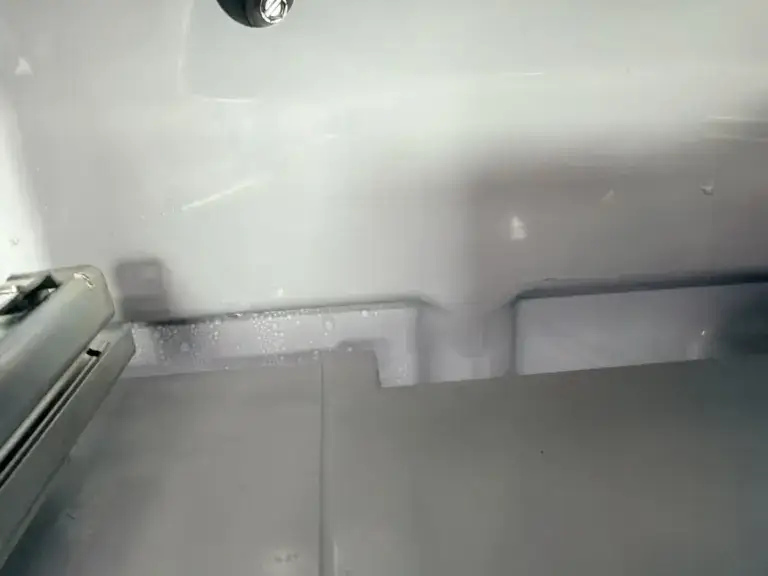 fridge repair close up back interior wall fridge showing condensation frost duri