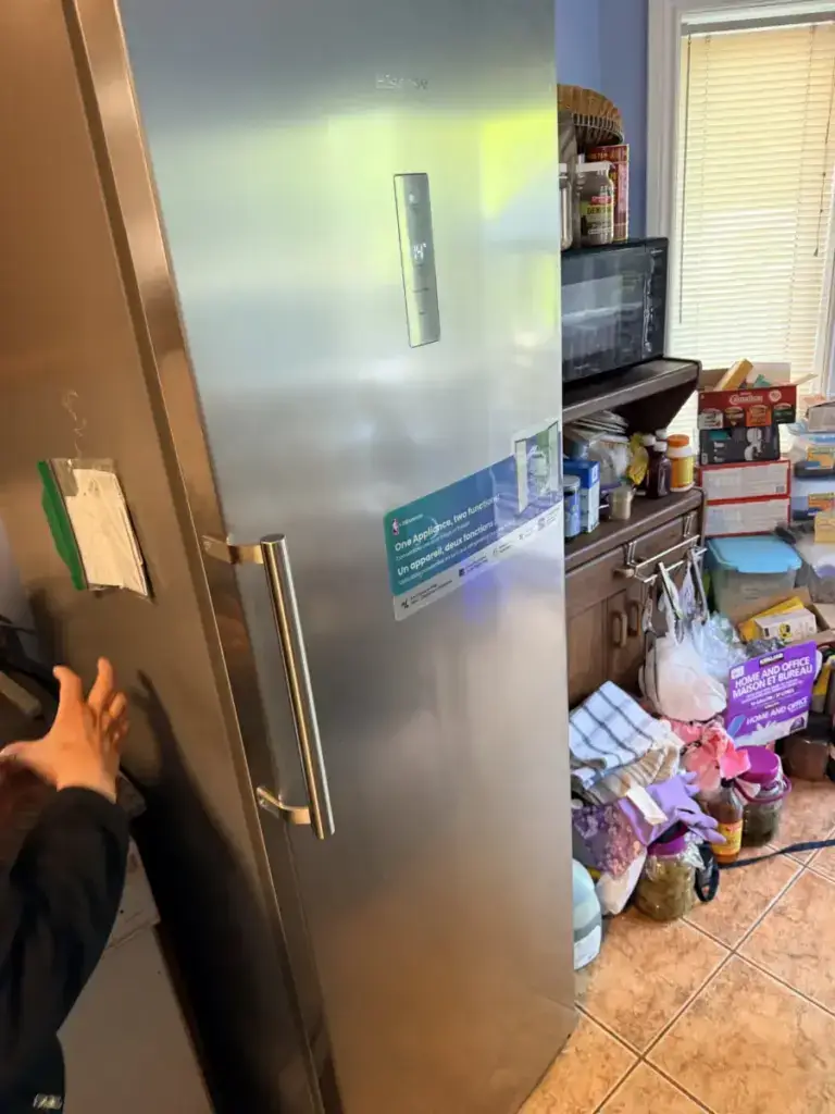 fridge repair technician inspecting hisense stainless steel upright fridge freez
