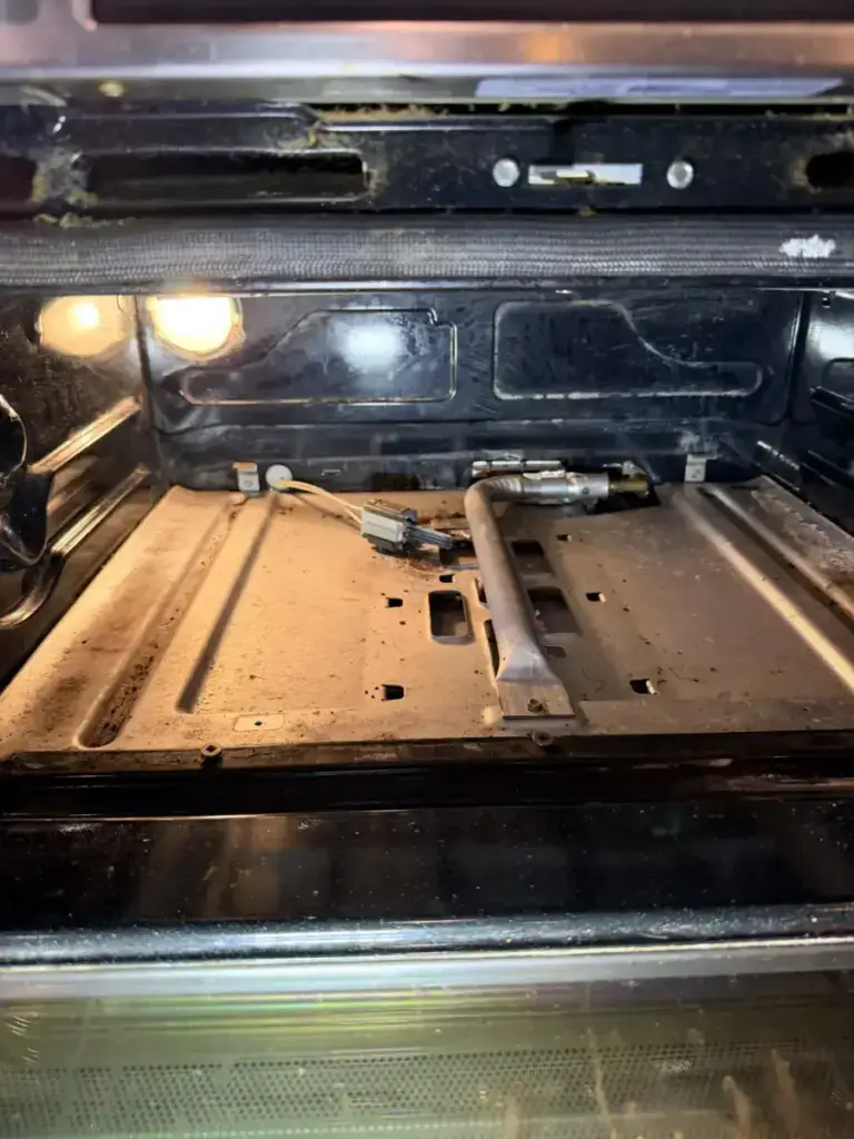 oven repair interior bottom soiled oven bake burner igniter exposed during repai