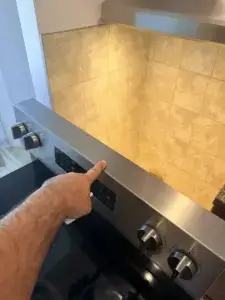 stove repair appliance forever technician pointing stainless control panel slide