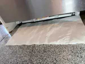 Paper towel placed under a dishwasher to trace a water leak - Appliance Forever appliance repair in Barrie, Ontario.