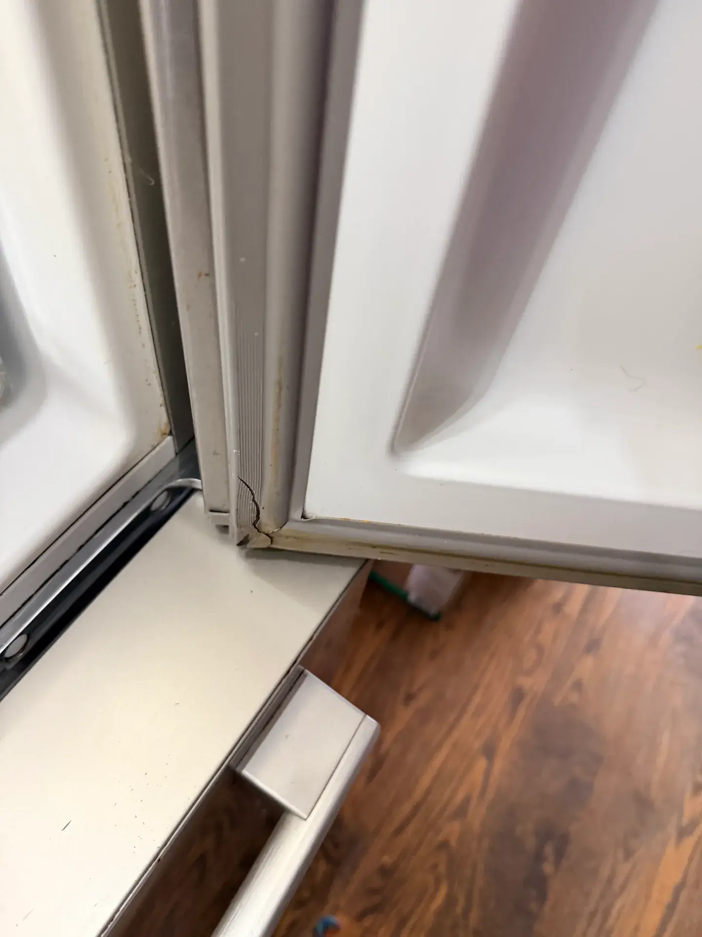 Refrigerator door open with a visible split in the rubber door gasket at its lower corner by the hinge, Richmond Hill
