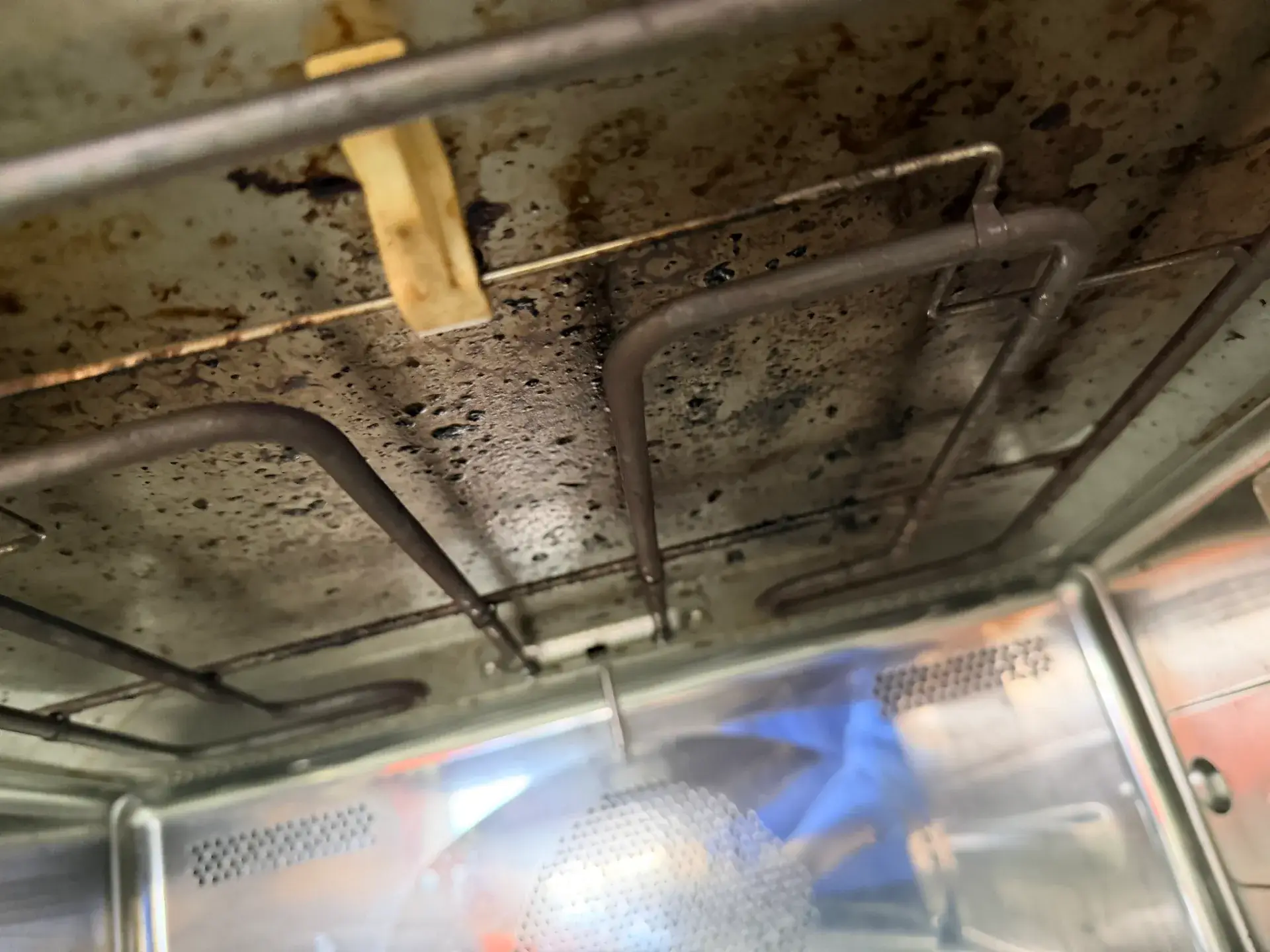 Grease spatter across the ceiling of a combination microwave cavity around the heating element