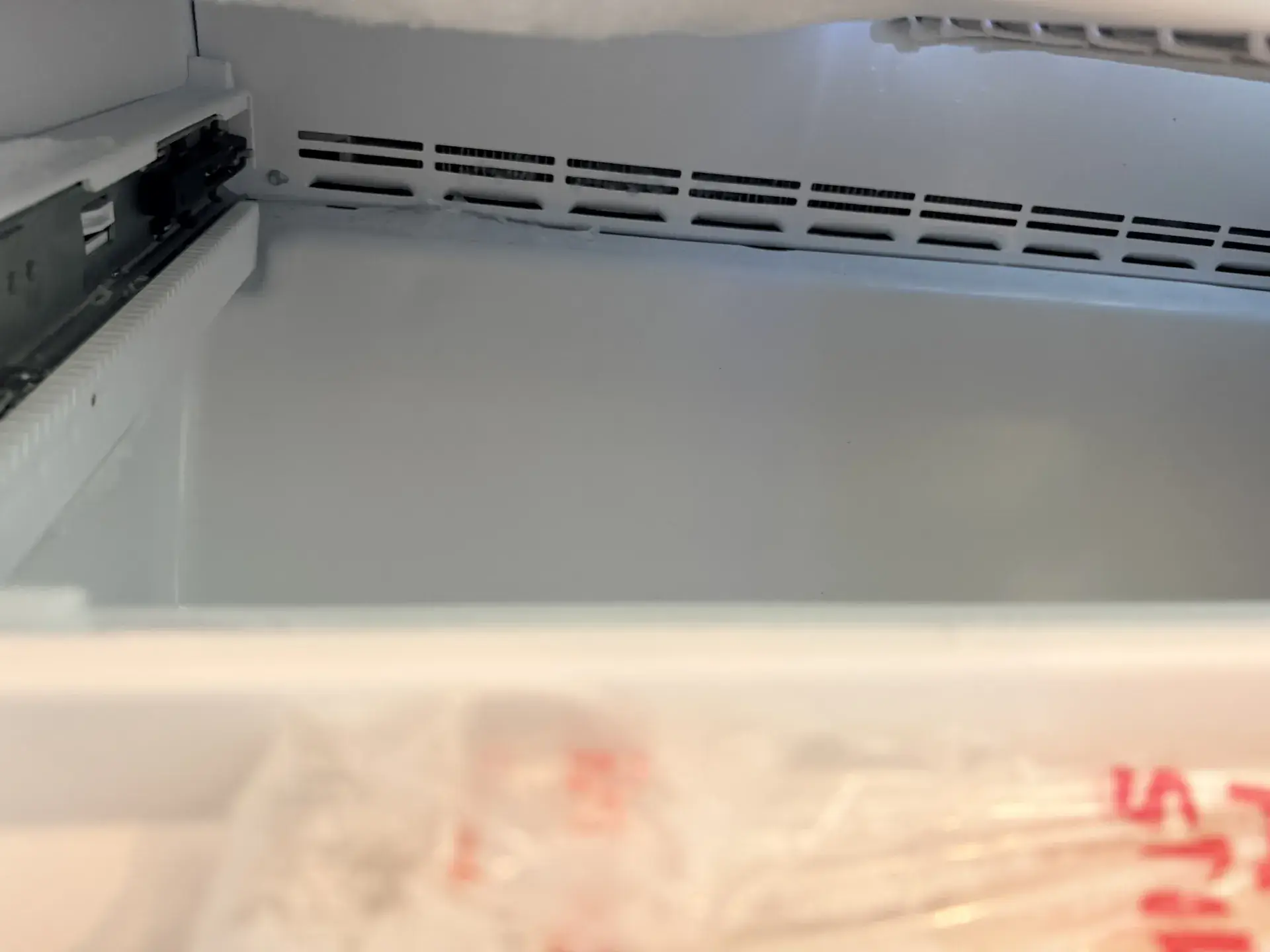 Freezer compartment rear vent grille with what may be light frost along its edge, Markham