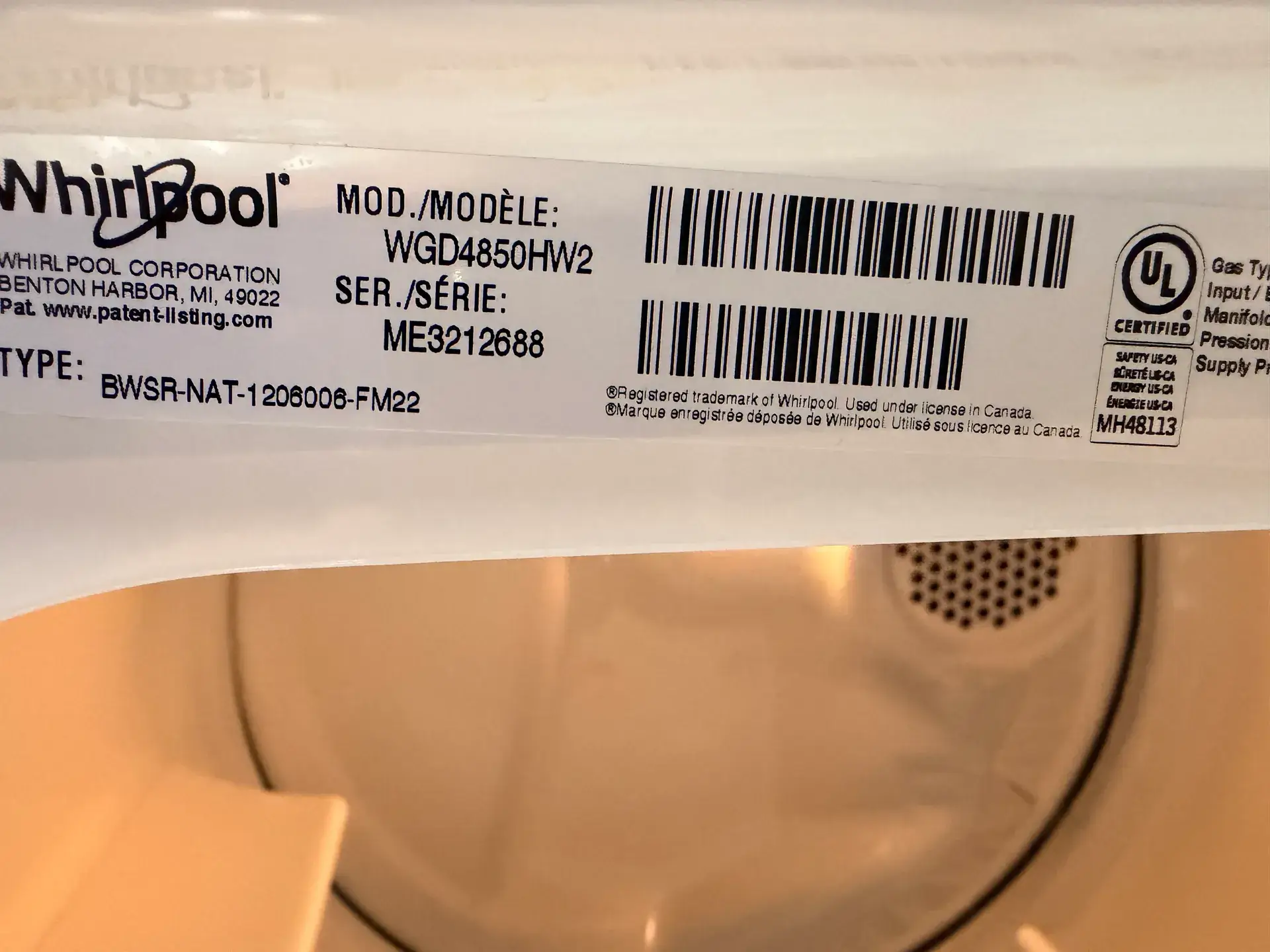 Whirlpool dryer rating label reading model WGD4850HW2 with gas type and input lines, above the open drum