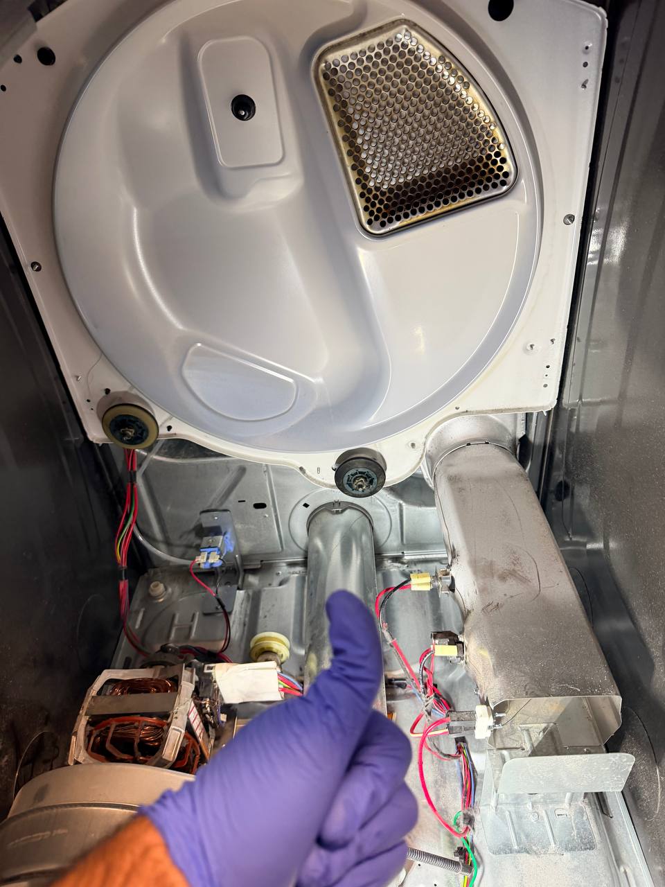 The same dryer cabinet cleaned, with a bare floor pan, a clean heater duct and blower housing, and wiring visible